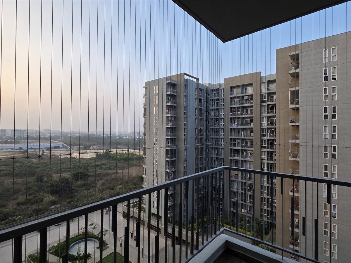 View through invisible grill wires across an apartment skyline at dusk