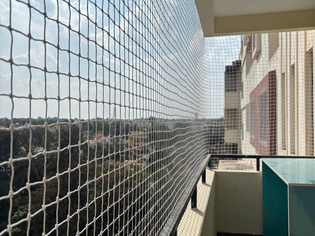 Pigeon net installed on a balcony overlooking a residential neighbourhood