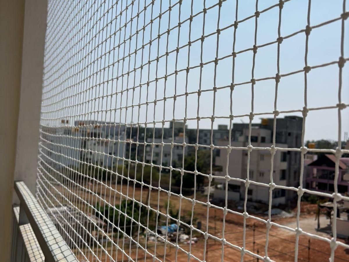 Pigeon net installed on a balcony overlooking open land